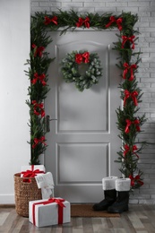 Stylish hallway interior with decorated door and Christmas gifts