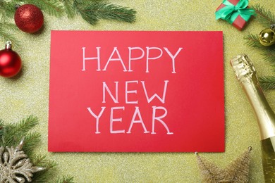Happy New Year greeting card. Red paper with phrase and decor on shiny background, flat lay