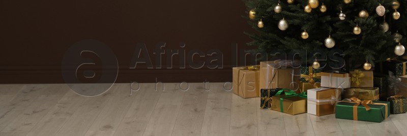 Beautifully decorated Christmas tree and gift boxes indoors, space for text. Banner design