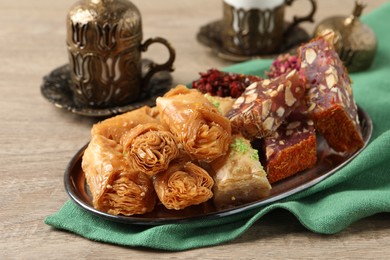 Photo of Tea, baklava dessert and Turkish delight served in vintage tea set on wooden table